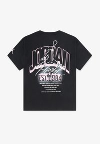 T-shirt nera con un grande grafico testuale in rosa e bianco sul retro, che include "JORDAN" e "EST. 1984", con una silhouette di pallone da basket.