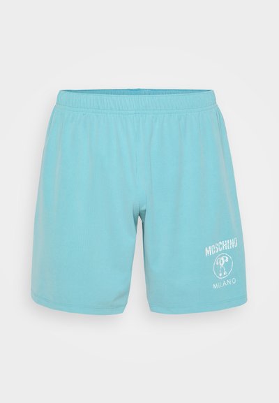 Világoskék rövidnadrág bordás anyagból, rugalmas derékkal. Fehér nyomott logóval és medve mintával rendelkezik, valamint a "MOSCHINO MILANO" felirattal.