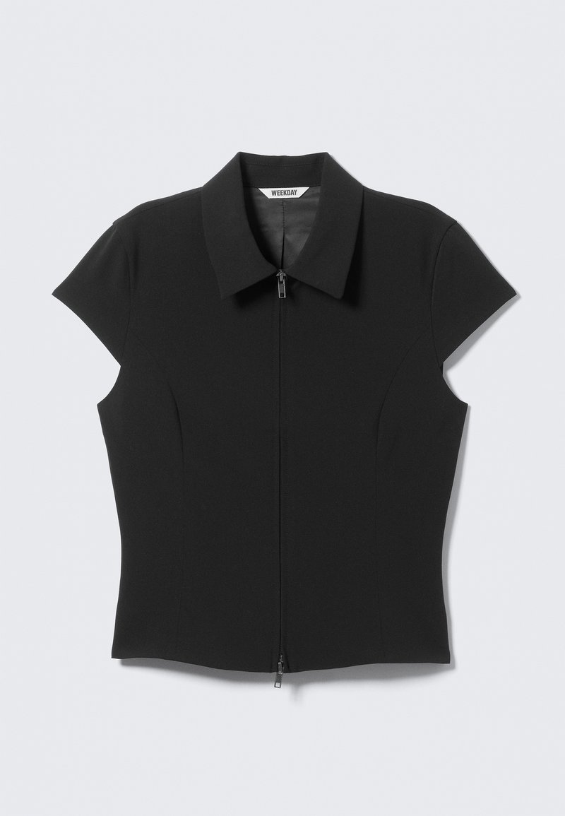 Haut noir à manches courtes avec fermeture éclair, coupe ajustée et col classique. Confectionné dans un matériau extensible pour une texture lisse.