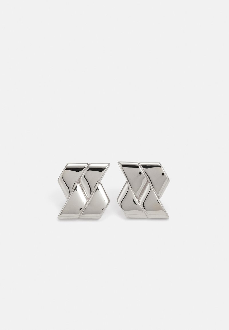 Silver metal earrings with a geometric design featuring interlocking shapes and a polished finish, reflecting light with smooth surfaces.