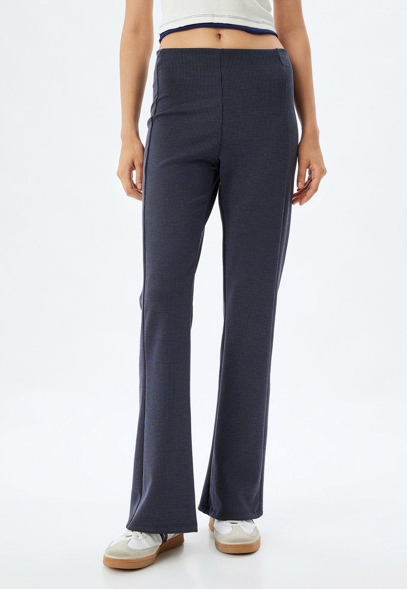 Navyblauwe, ribgebreide flared broek met een hoge taille, voorzien van een effen textuur en subtiele verticale strepen. Casual pasvorm en ontwerp.