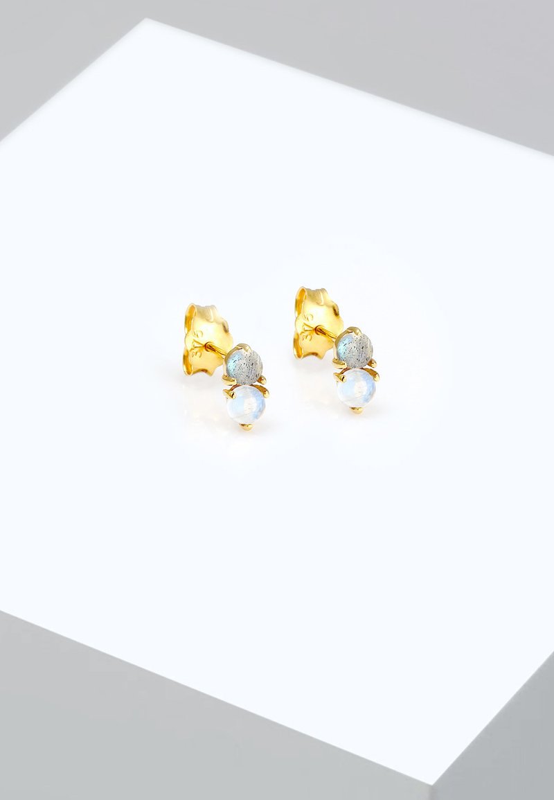 Guldtonet stud øreringe med lyseblå sten og en tekstureret bagside. Designet er elegant med rundede former og en poleret finish.