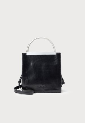 Sac à main en cuir noir avec une anse en arc argentée et une bandoulière amovible sur un fond blanc.