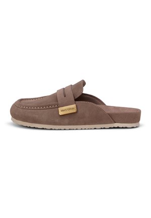 Καφέ μοκασίνι από σουέτ χωρίς κορδόνια με επίπεδη λαστιχένια σόλα και μικρή ορθογώνια χρυσή ετικέτα με τη λέξη "Marc O'Polo" στο λουράκι.