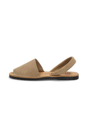 Sandalia plana de ante color tostado con punta abierta, tira trasera y suela de goma negra, colocada plana sobre fondo blanco.