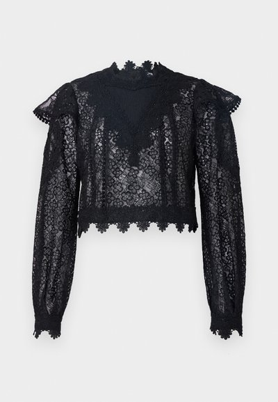 Black lace crop top featuring long sleeves, a high neck, and scalloped trim. Floral pattern with sheer texture throughout.