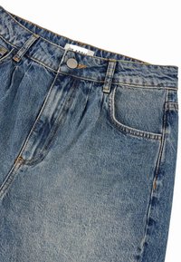 Lyseblå denimjeans med afslappet talje, knaplukning foroven og synlige syninger. Har let faldefarve og to frontlommer.