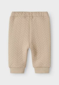 Bermudas de color beige con patrón de espiga, cintura elástica, puños acanalados y una textura suave, diseñadas para brindar comodidad y facilidad de uso.