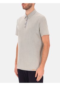 Lichtgrijze polo met korte mouwen en een button-down kraag, met een gestructureerde stof en een oranje accent bij de zoom.