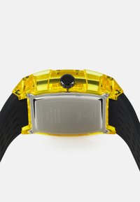 Gelbe rechteckige Uhr mit transparentem Kunststoffgehäuse, schwarzer Krone und Gummiband. Rückseite aus Edelstahl mit Markenlogo.