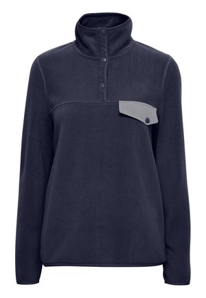 Sudadera de polar azul marino con cuello alto, tres botones y un bolsillo de parche gris con cierre a presión en el lado izquierdo del pecho. Textura suave.
