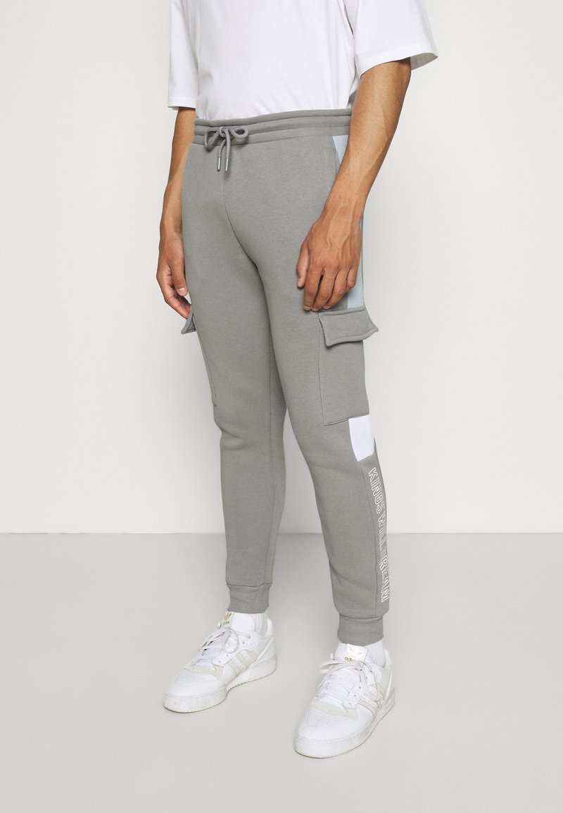 Graue Jogginghose mit figurbetonter Passform, elastischem Bund mit Kordelzug, seitlichen Cargotaschen und kontrastierenden hellblauen Akzenten.