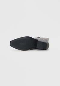 Black rubber sole with a textured surface, features a raised emblem and a flat profile, suitable for various shoe styles.