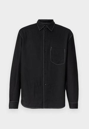 Zwarte lange mouw button-up overhemd met witte contrasterende stiksels, voorkant borstzak en puntige kraag, weergegeven op een effen achtergrond.