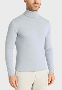 Maglione a collo alto grigio chiaro, realizzato in tessuto morbido, design aderente, maniche lunghe, superficie liscia e girocollo alto.