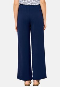 Námořnické široké kalhoty vyrobené z měkké tkaniny s elastickým pasem, s hladkou texturou a uvolněným střihem na lemu.