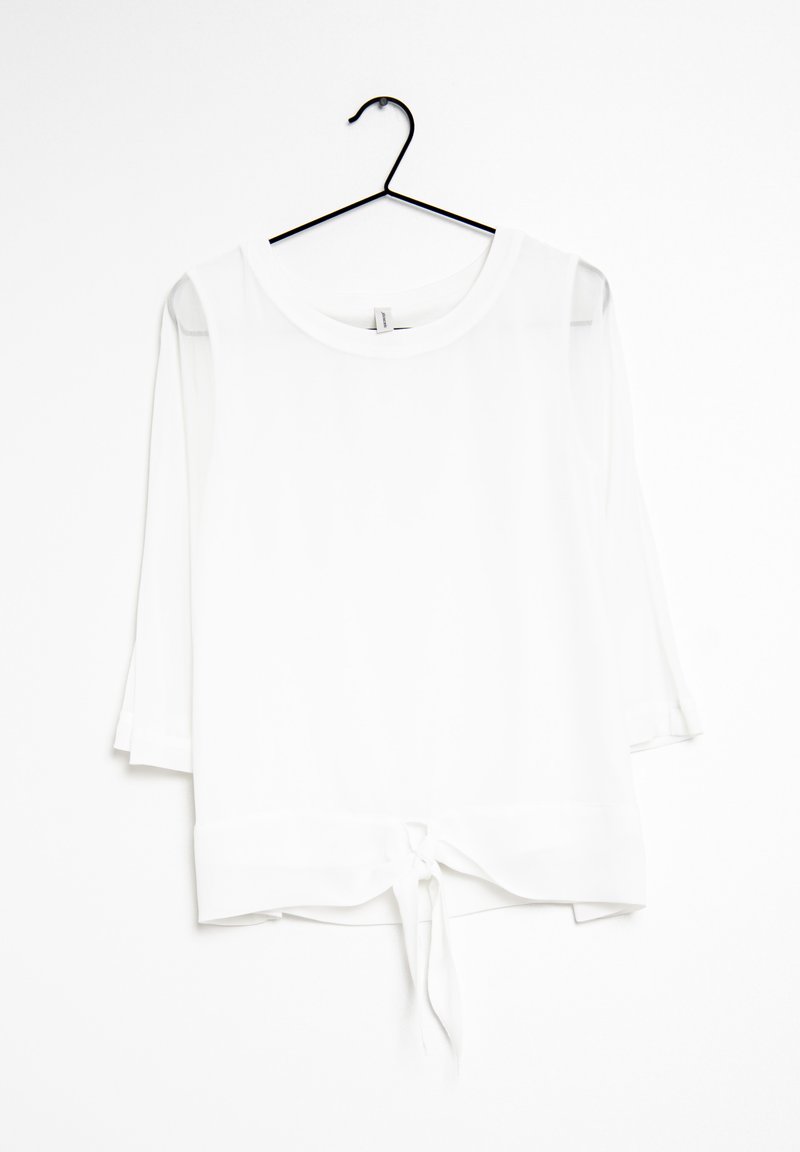 Blusa bianca realizzata in tessuto leggero, con scollatura rotonda, maniche a tre quarti e dettaglio di nodo all'orlo.