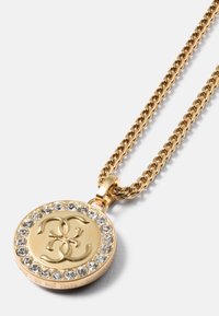 Colar de pendente em ouro apresentando um medalhão redondo com um logótipo no centro, rodeado por cristais transparentes, numa corrente torcida.