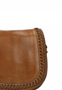 Bruine leren handtas met een gladde textuur, ronde klep en gedetailleerde stiksels langs de rand. Compact ontwerp met een minimalistische uitstraling.