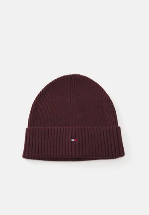 Bonnet en tricot bordeaux avec une texture côtelée, un revers replié et un petit patch logo avec des accents rouge, blanc et bleu.
