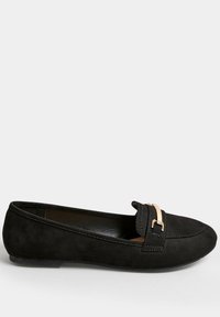 Scarpe flat in suede nero con un design cucito, stile slip-on, e un accento dorato nella parte anteriore. Presentano una superficie liscia e testurizzata.
