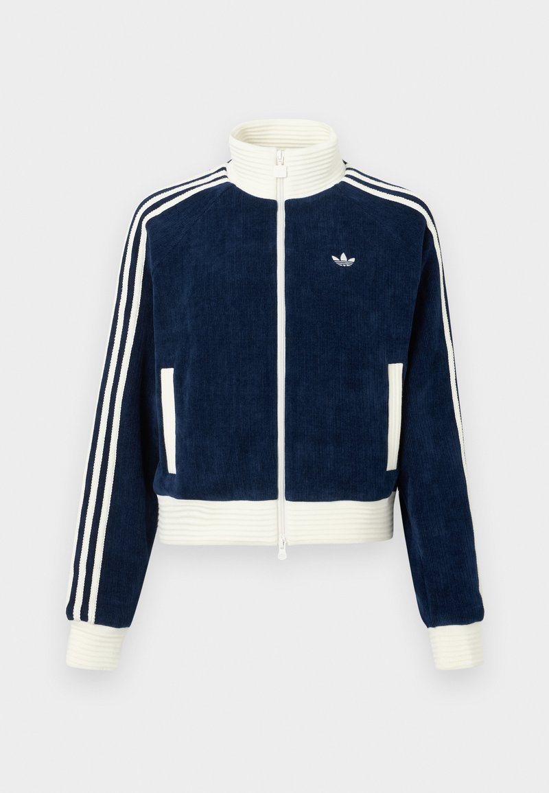 Giacca zip-up in corduroy blu navy con colletto e polsini a costine bianchi. Tre strisce bianche sulle maniche e piccolo logo sul petto. Due tasche frontali.
