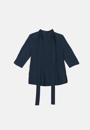 Blusa azul marino con escote en V, mangas de tres cuartos y un frente drapeado. Presenta aberturas laterales y costuras decorativas en los hombros. Tejido suave.
