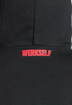 Sort sweatshirt med ribbet struktur, hvor ordet "WERKSELF" står med fed røde bogstaver på den nederste front.