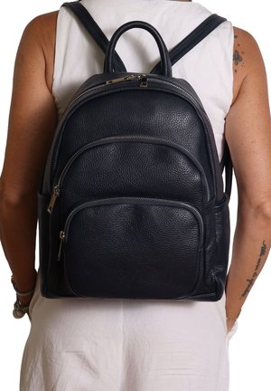 Sac en cuir marine avec finition texturée, double bretelles et plusieurs poches zippées à l'avant et dans le compartiment principal.