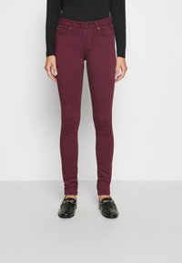 Jeans skinny burdeos con cierre de botones, dos bolsillos frontales y un diseño ajustado. Fabricados con una tela suave y elástica para mayor comodidad.