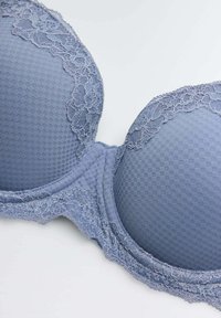 Sostén azul con encaje y relleno, fabricado con una tela texturizada de cuadros, que cuenta con un diseño de copa seamless y una banda inferior suave para mayor comodidad.