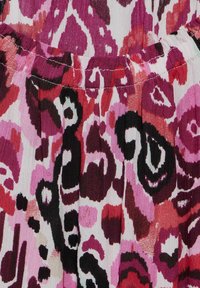 Il tessuto a motivo floreale presenta tonalità di rosa, rosso e nero; parte superiore arricciata con dettagli di cucitura; materiale morbido e testurizzato.
