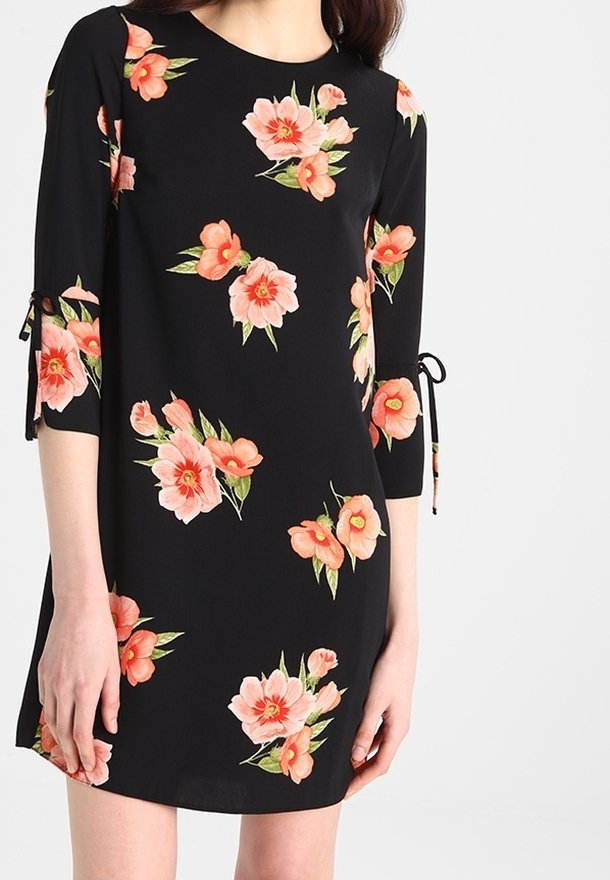 Czarna sukienka z rękawami trzy czwarte, z kwiatowym wzorem w odcieniach różu i pomarańczu oraz związaniami przy otworach rękawów. Gładka tekstura materiału.