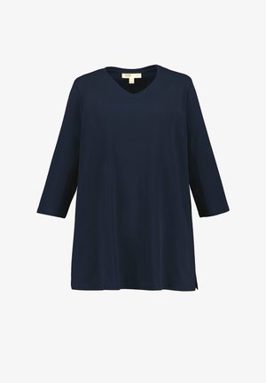 Tunic blu navy con scollo a V, maniche a tre quarti e vestibilità ampia. Realizzata in tessuto morbido con spacchi laterali per facilitare i movimenti.