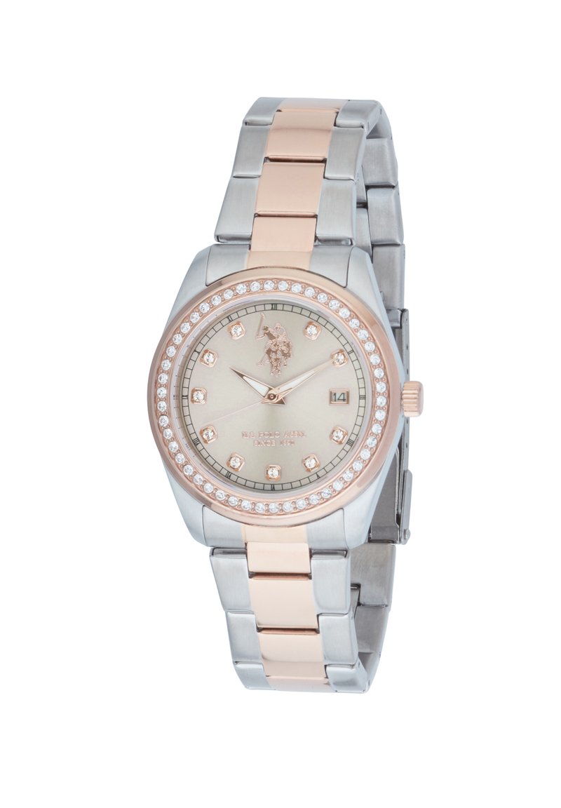 Orologio argento e rosa con cassa rotonda, accenti di cristallo, quadrante beige e bracciale a maglie metalliche. Presenta una visualizzazione della data e un dettaglio del logo.