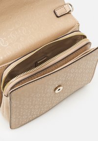 Beige håndtaske lavet af struktureret materiale med en guldlås, logo mønster og trykknaplukning. Indvendigt med to rum.