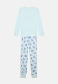 Blusa de manga longa azul clara com calças de pijama combinando, apresentando personagens de desenhos animados azuis e rosa sobre um fundo branco.