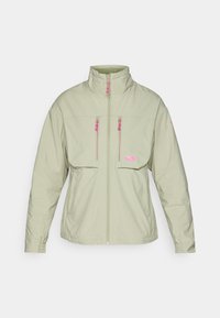 Veste zippée verte clair avec un col montant. Présente des accents de fermeture éclair rose et deux poches sur la poitrine. Texture lisse et design moderne.
