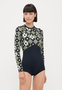 Langermet badedrakt med et mønstret topp i grønn og marine, med blomster- og geometriske design. Glatt stoff med elastisk passform.