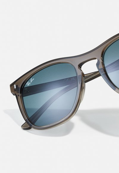 Слънчеви очила Ray-Ban с полупрозрачна кафява рамка, лещи с синкав оттенък, правоъгълна форма и тънки крачета. Логото е отпечатано на лещата.
