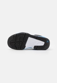 Černobílá podrážka boty s modrými akcenty, s vzorovanou gumovou podrážkou pro trakci a zakřivenými designovými prvky.