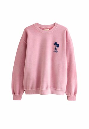 Sudadera rosa con cuello redondo, mangas largas y un pequeño gráfico de una palmera azul marino en el pecho izquierdo.