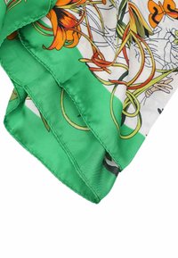 Foulard in seta con un bordo verde vibrante, caratterizzato da un motivo di fiori arancioni e viti intrecciate su sfondo bianco.