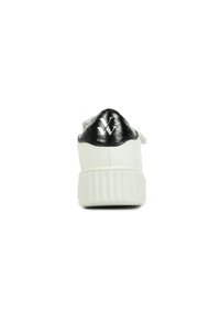 Baskets blanches avec un talon métallique noir, présentant une semelle blanche texturée et un accent logo sur le capuchon du talon. Fini lisse dans l'ensemble.