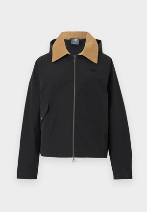 Veste noire zippée avec col en velours côtelé beige, manches longues et poche à rabat sur le côté avant gauche.