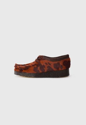 Scarpe con stampa animale marroni e arancioni, con una parte superiore texturizzata, caratterizzate da una finitura morbida e una suola in gomma nera, dal design a profilo basso.