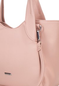 Różowa skórzana torba o gładkiej teksturze, z akcentem w postaci srebrnych elementów i subtelnym logo marki. Wyprofilowany kształt z podwójnymi uchwytami.