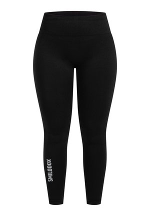 Zwarte leggings van gladde, elastische stof met een hoge tailleband. Opvallend detail is de witte logo-tekst op het onderste deel van het linkerbeen.