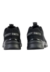 Scarpe sportive nere con tomaia in rete testurizzata, suola ammortizzata e un evidente marchio "TEDDY SMITH" sulla parte posteriore.
