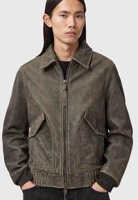 Καφέ δερμάτινο μπουφάν με γιακά, φερμουάρ στο μπροστινό μέρος και δύο μεγάλες πλαϊνές τσέπες. Διαθέτει υφή με vintage φινίρισμα και ριμπ μανσέτες.